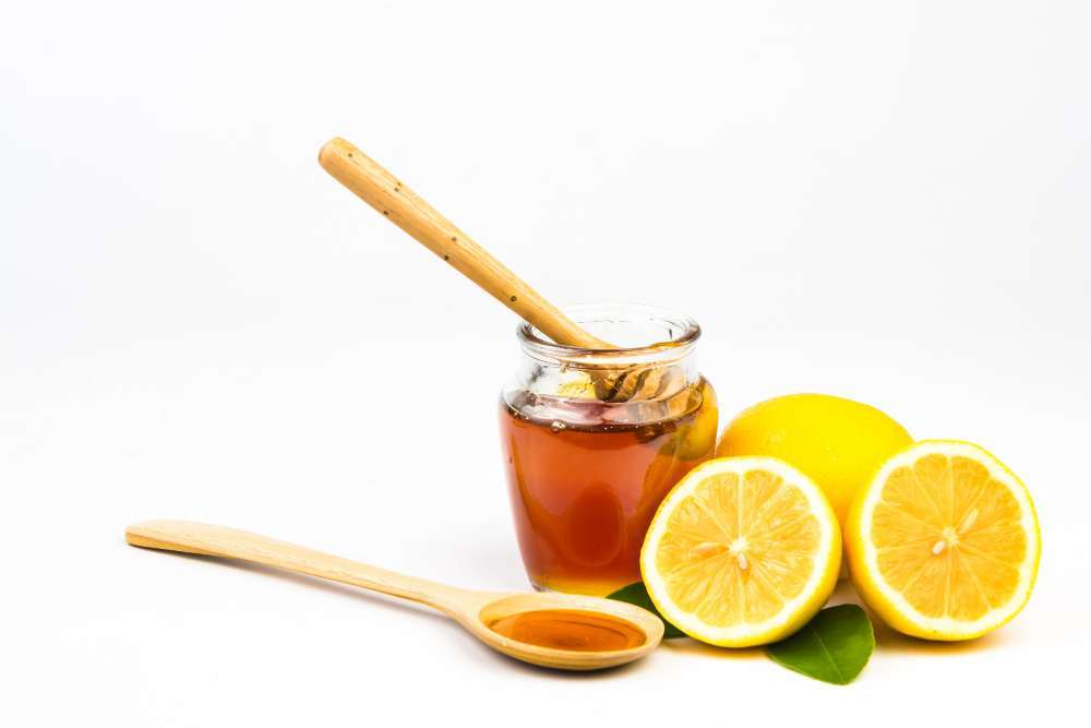 Glass jar of honey and fresh lemons used to make homemade electrolyte water for hydration and recovery in Florida homes