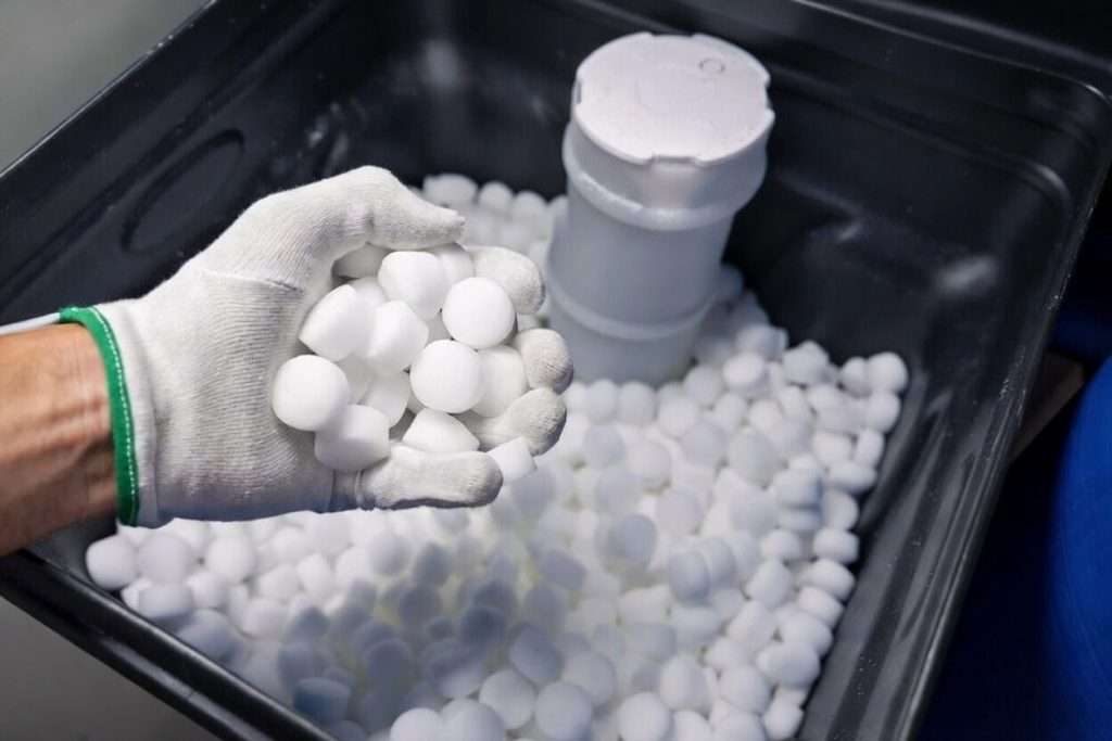 Technician adding high-purity water softener salt pellets to a salt-based water softener during scheduled salt delivery service in Tampa, Florida